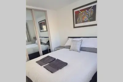 a bedroom with a bed with a towel on it at Craiglynn Holiday Apartment Loch Lomond in Balloch