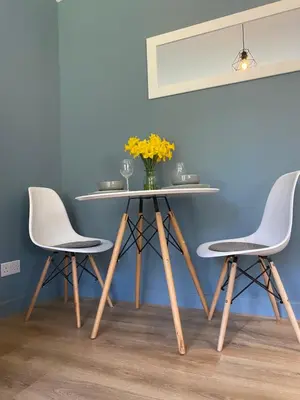 a table with two chairs and a vase with yellow flowers at Lynwood Studio in Oban