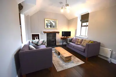 a living room with two couches and a fireplace at Arivean Cottage in Lochgoilhead