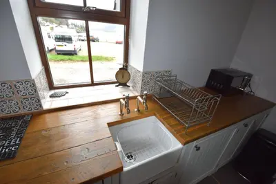 a kitchen counter with a sink and a window at Arivean Cottage in Lochgoilhead