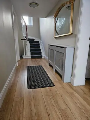 a hallway with stairs and a mirror and a rug at ALLARDYCE in Kincardine