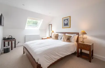 a bedroom with a large white bed and a window at Ardeonaig Hotel & Restaurant in Ardeonaig