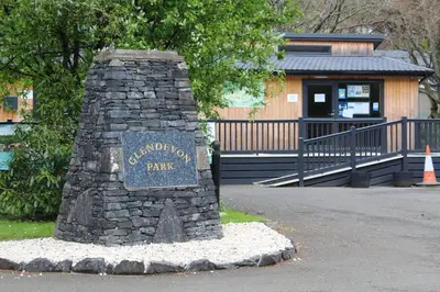 a sign on a stone pillar in front of a building at Lazy Days Lodge, Glendevon, Perthshire in Glendevon