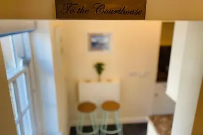 a doll house with two stools and a sign that reads to the comfortable at The Old Jail Apartment, Inveraray in Inveraray