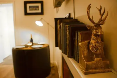 a table with a trophy of a deer on a wall at The Old Jail Apartment, Inveraray in Inveraray