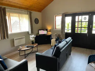 a living room with a couch and a tv at Wellsfield Farm Holiday Lodges in Stirling