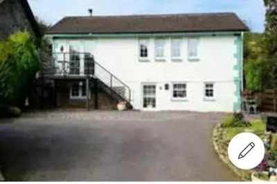 a large white house with a staircase in front of it at THE BOTHY SUITE BY TEMPLE WOOD in Lochgilphead