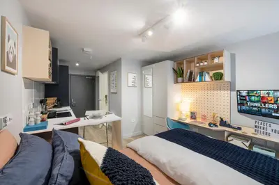 a living room with a bed and a kitchen at Silk Mill Edinburgh in Edinburgh