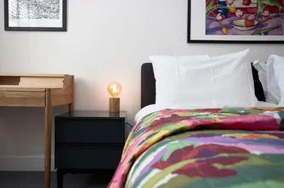 a bedroom with a bed and a table with a lamp at JOIVY Splendid Apartment in New Town in Edinburgh