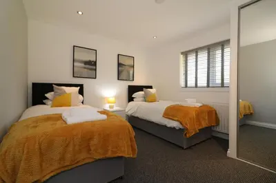 a bedroom with two beds and a mirror at Signature - Railway House 5 bed in Maryhill