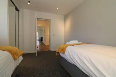 a room with two beds and a hallway at Signature - Railway House 5 bed in Maryhill
