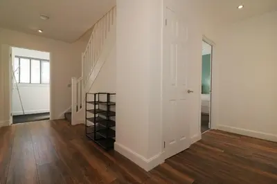 a hallway with a white wall and a stair case at Signature - Railway House 5 bed in Maryhill