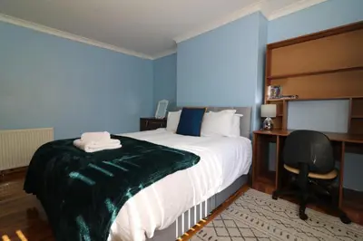 a bedroom with a bed and a desk and a chair at Signature - Dumbreck House in Glasgow