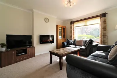 a living room with a couch and a tv at Signature - Dumbreck House in Glasgow