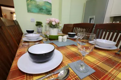 a table with a bowl and plates and glasses on it at Signature - Dumbreck House in Glasgow