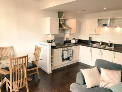 a kitchen and living room with a couch and a table at Dreamhouse at Oswald Street, City Centre in Glasgow