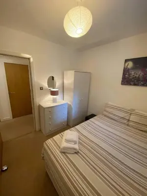 a bedroom with two beds and a dresser and a lamp at Dreamhouse at Oswald Street, City Centre in Glasgow