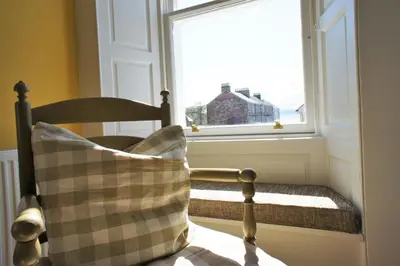 a pillow sitting on a chair in front of a window at 136 West Princes Street in Helensburgh