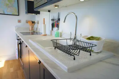 a kitchen counter with a sink with a dish drying rack at 136 West Princes Street in Helensburgh