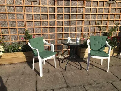 two chairs and a table in front of a brick wall at 136 West Princes Street in Helensburgh