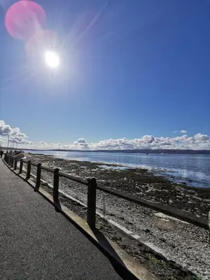 a fence next to a beach with the ocean at 136 West Princes Street in Helensburgh