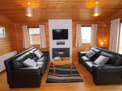 a living room with two leather couches and a fireplace at Chalet Loch Leven Lodge 11 by Interhome in Kinross