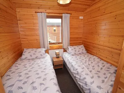 two beds in a cabin with a window at Chalet Loch Leven Lodge 11 by Interhome in Kinross