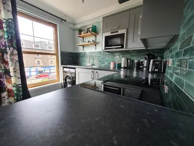 a kitchen with a black counter top and a window at EDEN Apartment, Oban in Oban