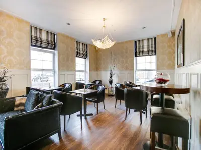 a dining room with chairs and a table at OYO Gin House Hotel in Greenock