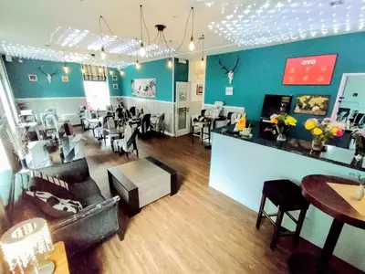 a salon with tables and chairs in a room at OYO Gin House Hotel in Greenock