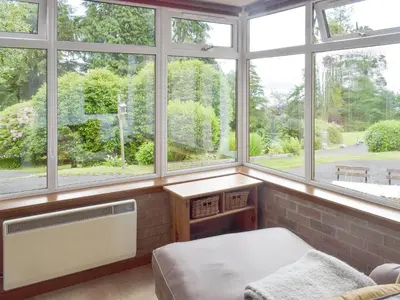 a room with windows and a bed and a radiator at Cluniter Cottage in Innellan