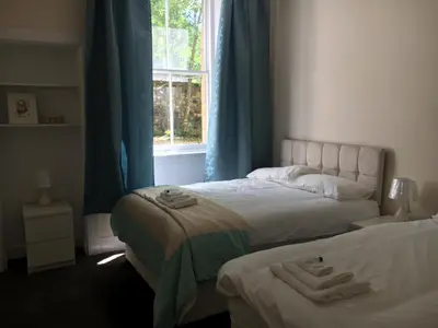 a bedroom with two beds and a window at 3 Bed Central Apartment - Pet Friendly & Parking in Edinburgh