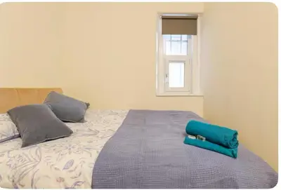 a bed with a blue pillow on top of it at 3 Bed Central Apartment - Pet Friendly & Parking in Edinburgh