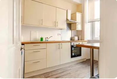 a white kitchen with white cabinets and a sink at 3 Bed Central Apartment - Pet Friendly & Parking in Edinburgh