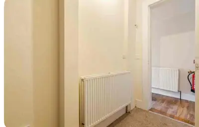 a room with a white wall and a radiator at 3 Bed Central Apartment - Pet Friendly & Parking in Edinburgh