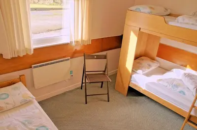 a bedroom with two bunk beds and a chair at Inveraray Hostel in Inveraray