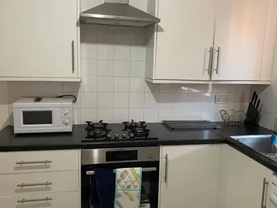 a kitchen with a stove and a microwave at Dada House in Glasgow