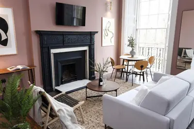 a living room with a white couch and a fireplace at 29 Queen Street Aparthotel in Edinburgh
