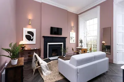 a living room with a white couch and a fireplace at 29 Queen Street Aparthotel in Edinburgh