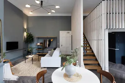 a living room with a white couch and a staircase at 29 Queen Street Aparthotel in Edinburgh