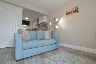 a blue couch in a living room with a door at McCaig's Way in Oban