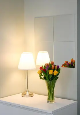 a table with a vase of flowers and a lamp at McCaig's Way in Oban