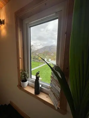 a cat sitting on a window sill looking out at Taigh Mara(Marine House) 2 bed Apartment in Fort William