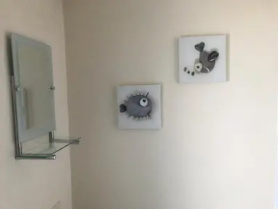 a bathroom with two pictures and a mirror on the wall at Eilidh’s Guest House in Port Ellen