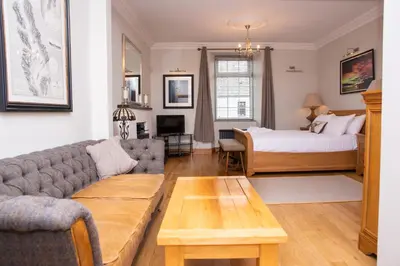 a living room with a couch and a bed at Braeside Guest House, Loch Lomond in Drymen