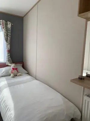 a teddy bear sitting on a bed in a bedroom at The Roecliffe 54 in Dunoon
