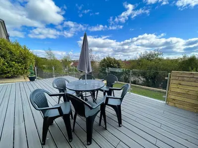 a table and chairs with an umbrella on a deck at Beautifully Designed Pollok House in Glasgow