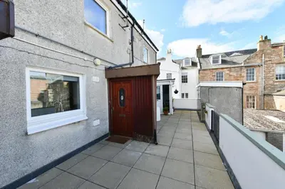 a red door on the side of a building at Mews House in Ayr