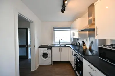 a kitchen with a sink and a washing machine at Mews House in Ayr