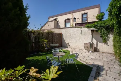 a patio with chairs and a table in front of a house at Southside Flat with Private Garden! in Glasgow